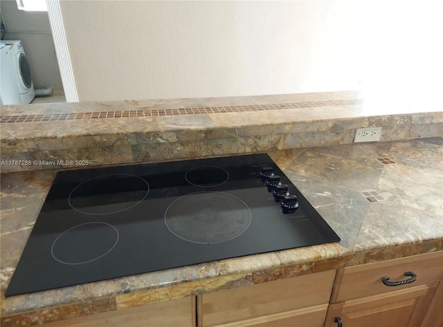 interior details featuring black electric cooktop and washer / clothes dryer