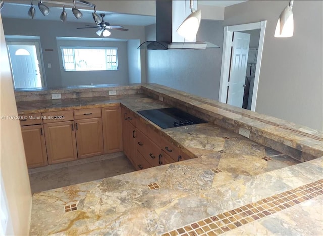 kitchen with visible vents, island range hood, pendant lighting, black electric stovetop, and ceiling fan