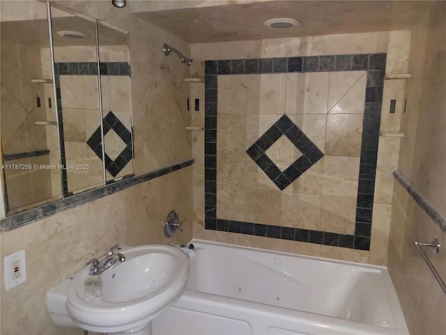 full bath with shower / bathing tub combination, tile walls, and a sink