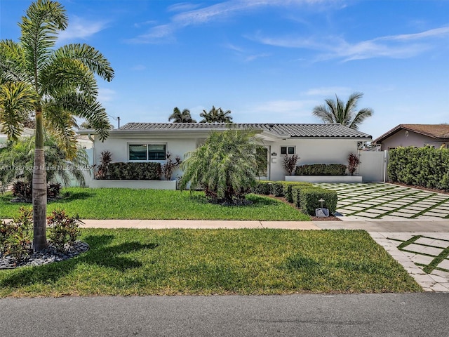 view of front of property featuring stucco siding, an attached garage, decorative driveway, and a front yard