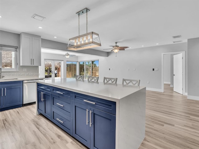 kitchen with light countertops, dishwasher, visible vents, a ceiling fan, and light wood-style flooring