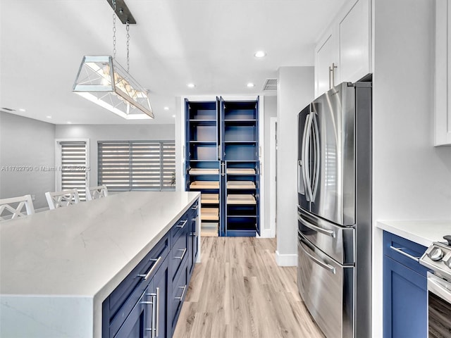 kitchen featuring blue cabinetry, appliances with stainless steel finishes, light wood finished floors, and white cabinets