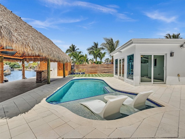 view of swimming pool featuring a fenced backyard, a fenced in pool, a water view, and a patio