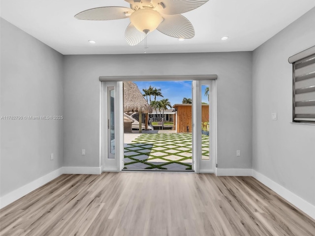spare room featuring baseboards, a ceiling fan, wood finished floors, and recessed lighting