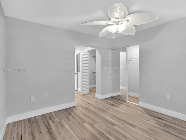unfurnished bedroom with light wood-type flooring, baseboards, a closet, and ceiling fan