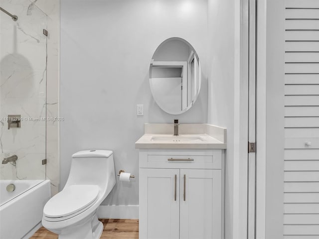 full bath with toilet, vanity, wood finished floors, and  shower combination