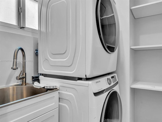 laundry room with cabinet space, stacked washing maching and dryer, and a sink