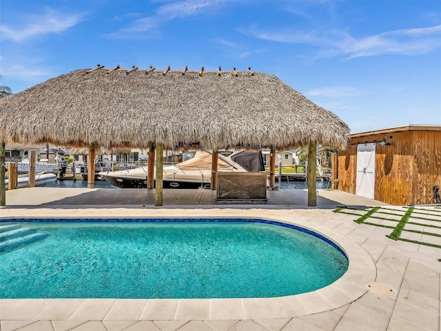 pool featuring a dock, a gazebo, and a water view