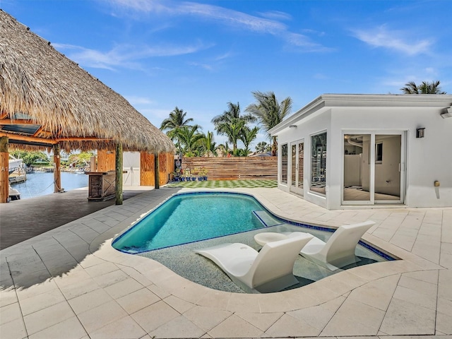 view of swimming pool featuring a fenced in pool, a fenced backyard, a water view, an outdoor structure, and a patio