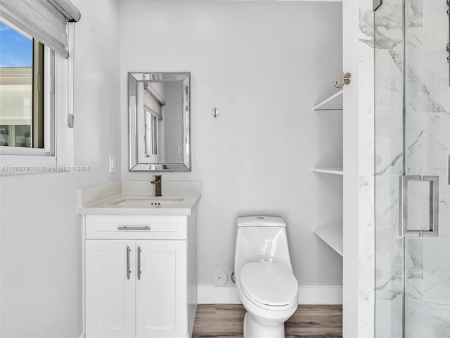 full bath featuring wood finished floors, toilet, vanity, a marble finish shower, and baseboards