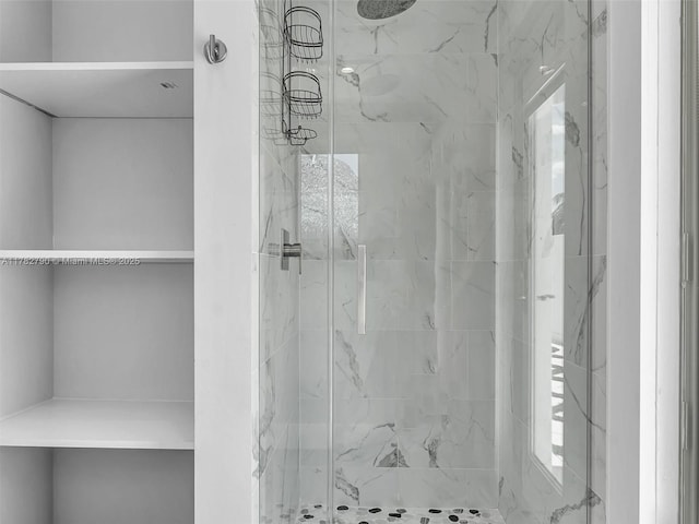 bathroom featuring a marble finish shower