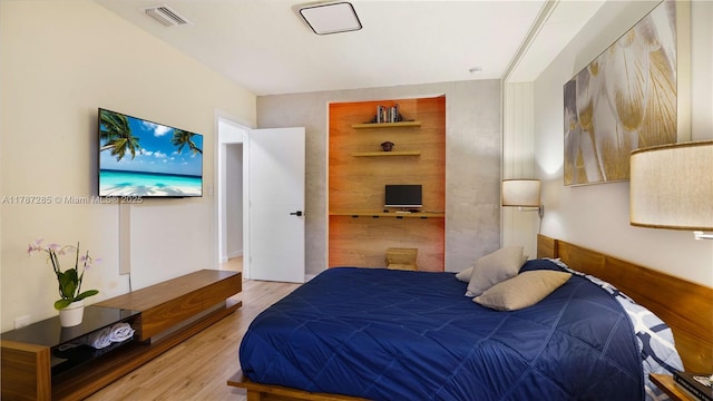 bedroom featuring wood finished floors and visible vents