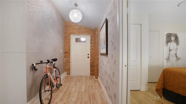 hallway with lofted ceiling and light wood-style floors