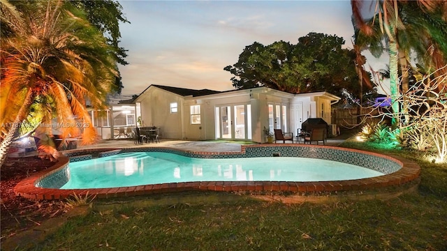 view of pool featuring french doors, grilling area, fence, a patio, and a fenced in pool