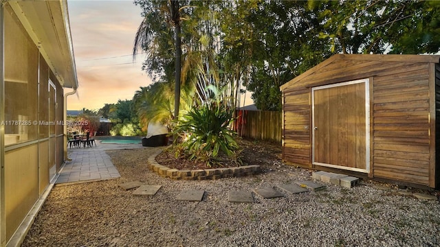 view of yard featuring a storage unit, a fenced in pool, a fenced backyard, a patio area, and an outdoor structure