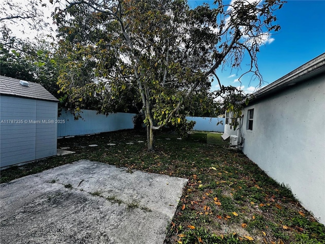 view of yard featuring a fenced backyard, an outdoor structure, and a patio area