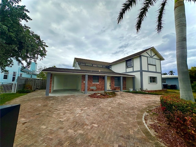 2727 NE 31st Ct, Lighthouse Point, FL 33064 - back of house with fence, an attached carport, and curved driveway