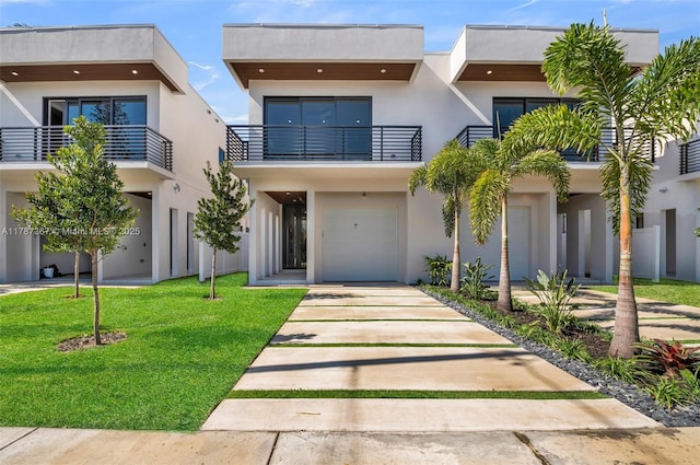 915 NE 17th Ter, Fort Lauderdale, FL 33304 - contemporary home with stucco siding, a front lawn, concrete driveway, and a garage