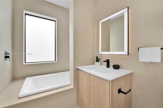 915 NE 17th Ter, Fort Lauderdale, FL 33304 - full bathroom featuring tiled tub, vanity, and tile walls
