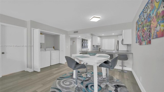 dining space with baseboards, recessed lighting, light wood-style floors, visible vents, and separate washer and dryer