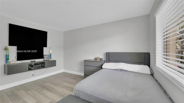 bedroom with baseboards and wood finished floors