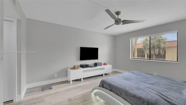 bedroom with light wood finished floors, baseboards, and ceiling fan