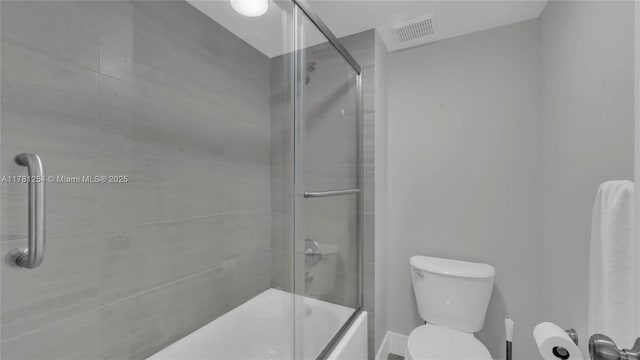 full bathroom with combined bath / shower with glass door, visible vents, and toilet