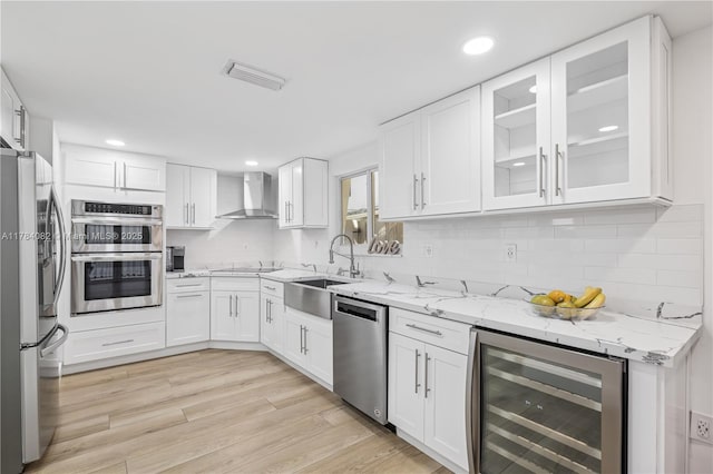 2905 Day Ave Unit 2A, Miami, FL 33133 - kitchen with beverage cooler, appliances with stainless steel finishes, wall chimney range hood, a sink, and white cabinetry