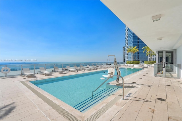 community pool featuring a patio area and a water view