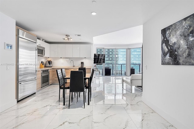dining space featuring light marble finish flooring and baseboards