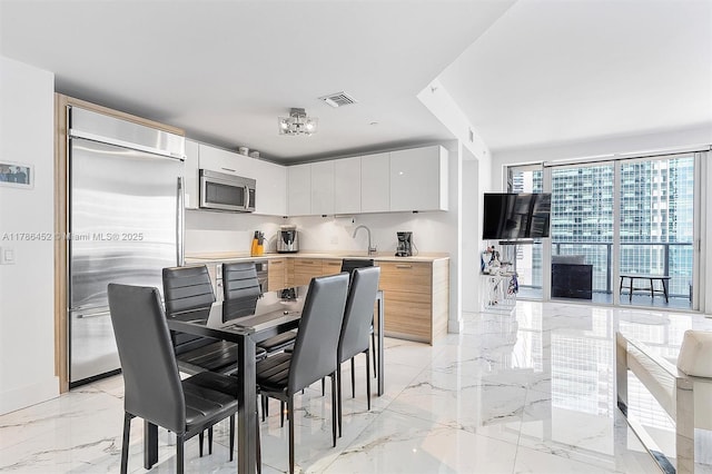 dining space featuring light marble finish floors and baseboards