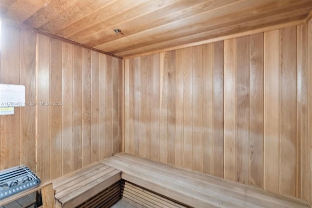 relaxing sauna / steam room featuring wooden ceiling and wooden walls