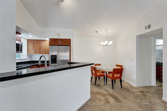 3460 N Pinewalk Dr N Unit 321, Margate, FL 33063 - kitchen with stainless steel appliances, a peninsula, a textured ceiling, a chandelier, and hanging light fixtures