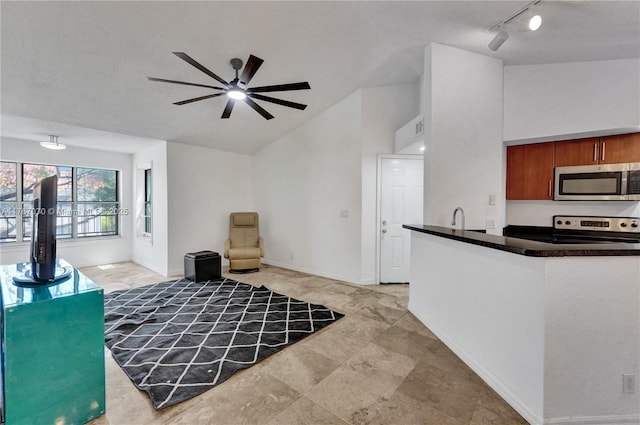 3460 N Pinewalk Dr N Unit 321, Margate, FL 33063 - kitchen with stainless steel appliances, lofted ceiling, track lighting, dark countertops, and brown cabinetry