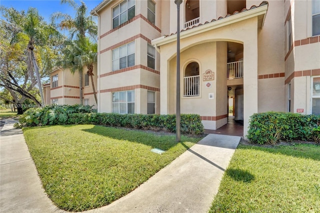 3460 N Pinewalk Dr N Unit 321, Margate, FL 33063 - view of exterior entry with stucco siding and a yard