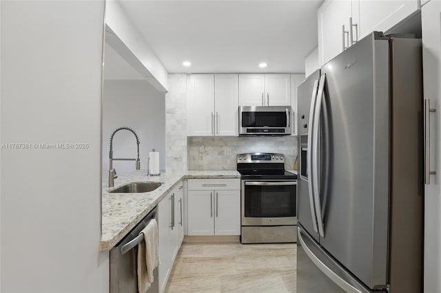 1831 NE 38th St Unit 402, Oakland Park, FL 33308 - kitchen with appliances with stainless steel finishes, a sink, light stone counters, white cabinets, and recessed lighting
