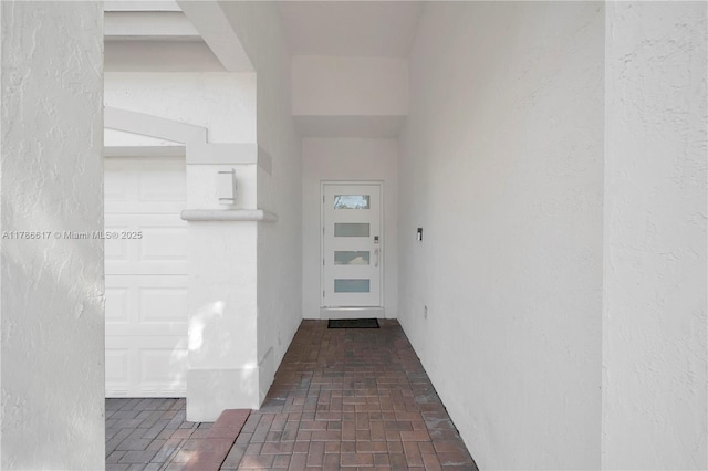 interior space featuring brick floor and a textured wall