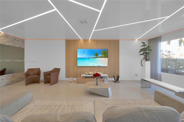 living area with a high ceiling, tile patterned flooring, and visible vents