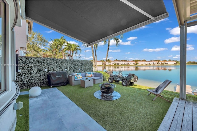 view of yard with a patio, an outdoor living space with a fire pit, and a water view