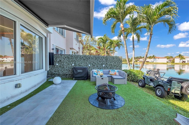 view of yard with a water view and an outdoor living space with a fire pit