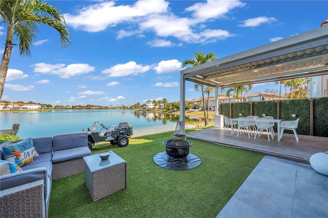 view of yard featuring a deck with water view, an outdoor living space with a fire pit, and outdoor dining space