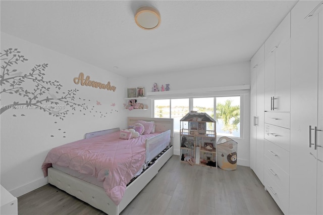 bedroom featuring baseboards and light wood-style flooring