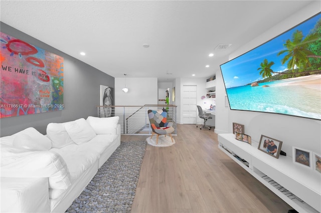 living area with recessed lighting, wood finished floors, and visible vents
