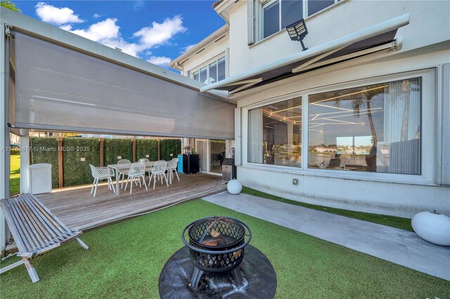 6694 NW 107th Pl, Doral, FL 33178 - view of grassy yard with a wooden deck, an outdoor fire pit, and outdoor dining area
