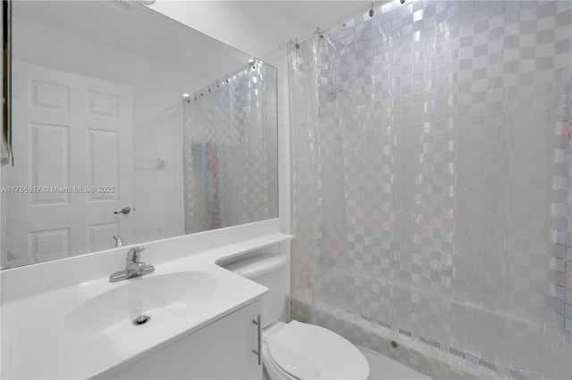 full bathroom with toilet, vanity, and tiled shower