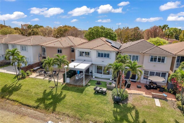 6694 NW 107th Pl, Doral, FL 33178 - back of property featuring a patio, roof mounted solar panels, stucco siding, a tile roof, and a residential view
