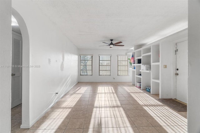 3111 Coral Springs Dr Unit 211, Coral Springs, FL 33065 - spare room with a ceiling fan, arched walkways, light tile patterned floors, and a textured ceiling