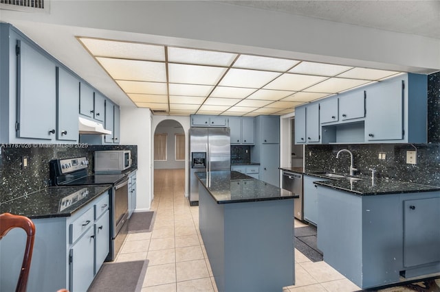 3111 Coral Springs Dr Unit 211, Coral Springs, FL 33065 - kitchen featuring appliances with stainless steel finishes, a sink, under cabinet range hood, arched walkways, and light tile patterned flooring
