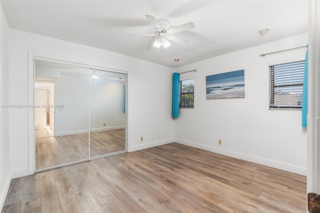 3111 Coral Springs Dr Unit 211, Coral Springs, FL 33065 - unfurnished bedroom featuring wood finished floors, a closet, baseboards, and a textured ceiling