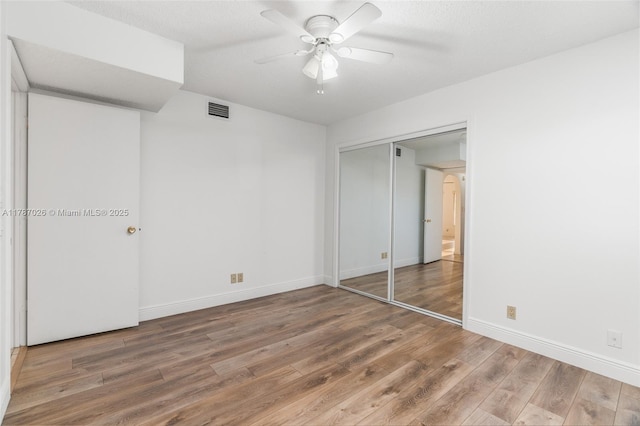 3111 Coral Springs Dr Unit 211, Coral Springs, FL 33065 - unfurnished bedroom featuring wood finished floors, baseboards, a closet, and a ceiling fan